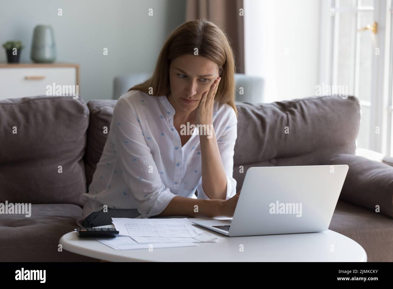 Une femme gère les finances, pense à des services publics domestiques élevés se sent stressée Banque D'Images