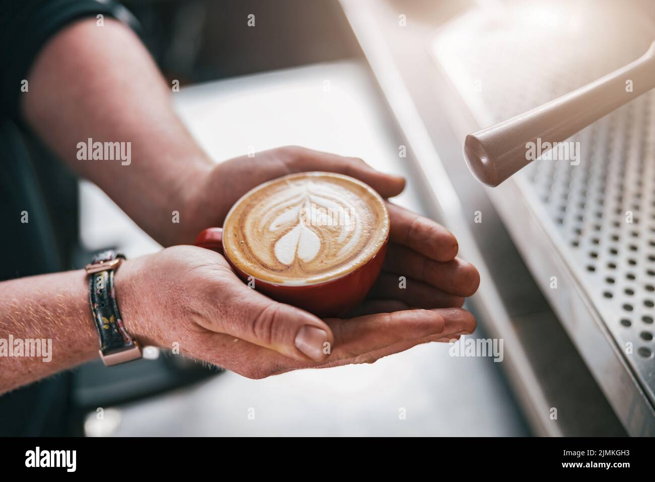 Gros plan des mains de Barista hommes tenant un cappuccino ou une tasse de latte frais dans un café Banque D'Images