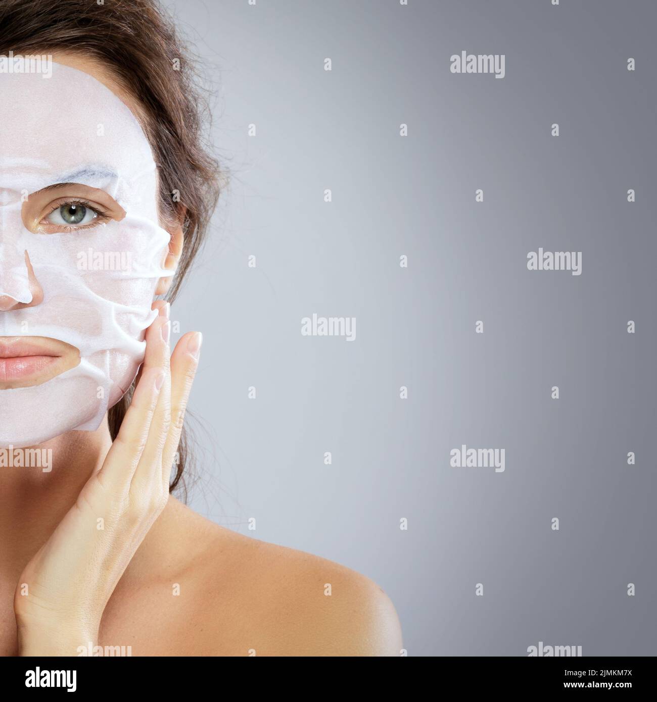 Femme avec un masque hydratant en tissu sur son visage Banque D'Images