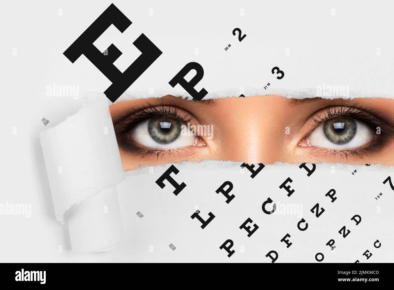 Femme regardant à travers un paper tordé avec un graphique des yeux Banque D'Images