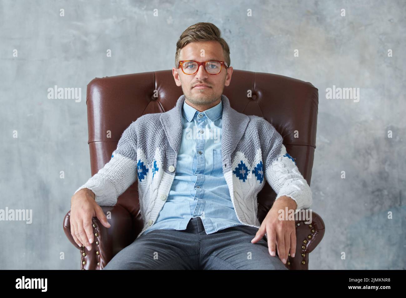 Portrait d'un homme intelligent élégant avec des lunettes fixe dans l'appareil photo, bonne vue, petite, non rasé, charismatique chemise bleue, g Banque D'Images