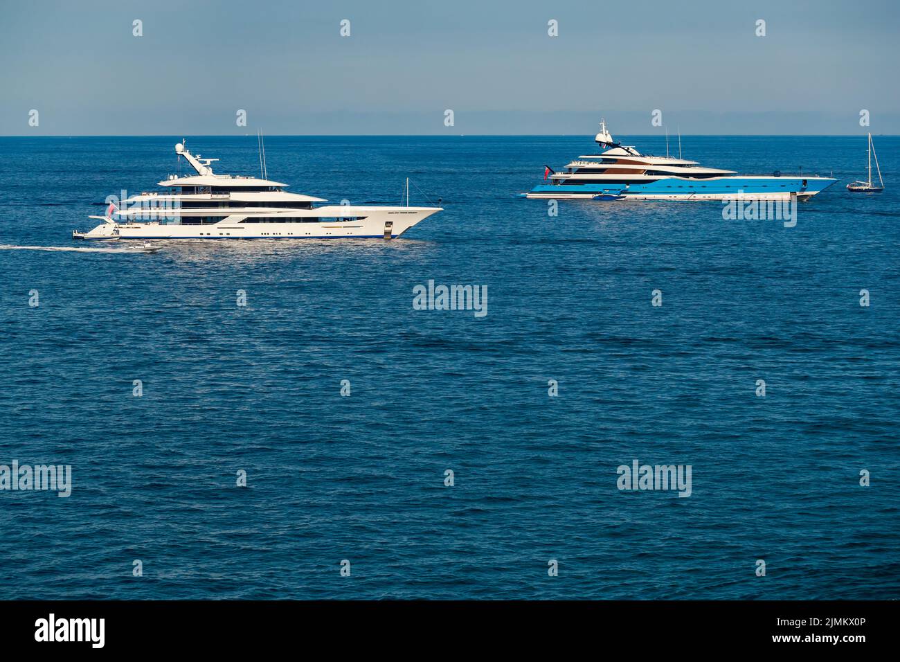 Les deux immenses yachts sont amarrés en mer par temps ensoleillé, la main courante chromée, le reflet du soleil sur le panneau brillant du moteur Banque D'Images