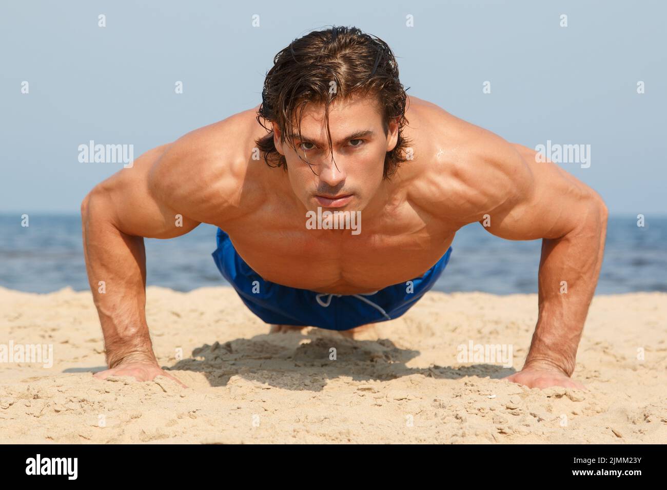 Homme musclé pendant son entraînement sur la plage Banque D'Images