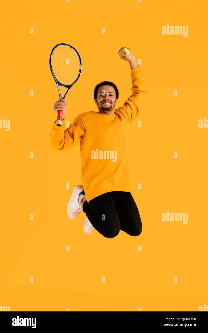 Portrait jeune homme sautant avec une raquette de tennis Banque D'Images