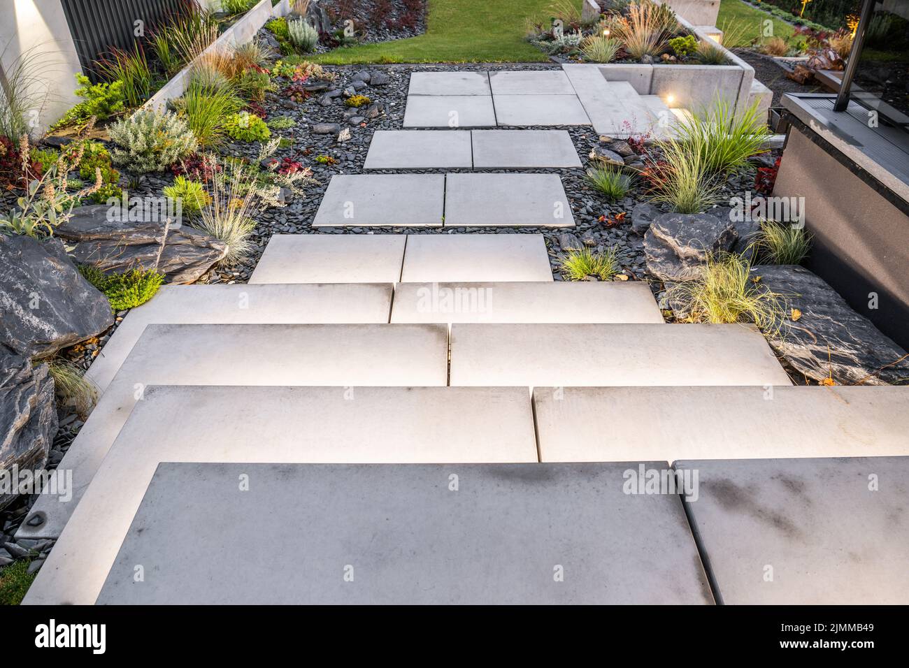 Jardin résidentiel moderne avec grands escaliers en béton éclairés. Rockery Garden Design. Banque D'Images