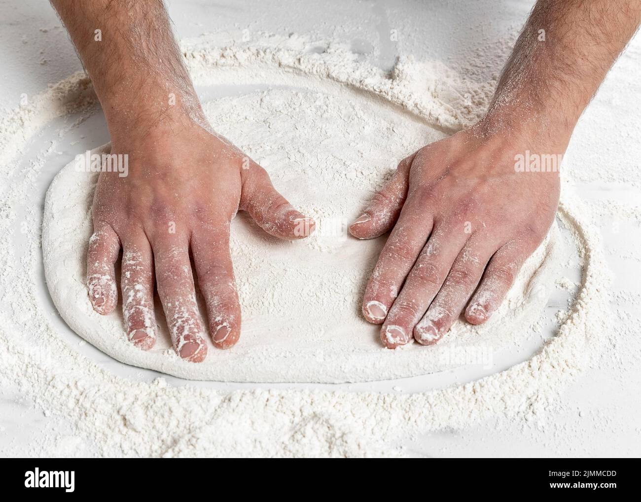 Homme grand angle pétriant la pâte à pizza Banque D'Images