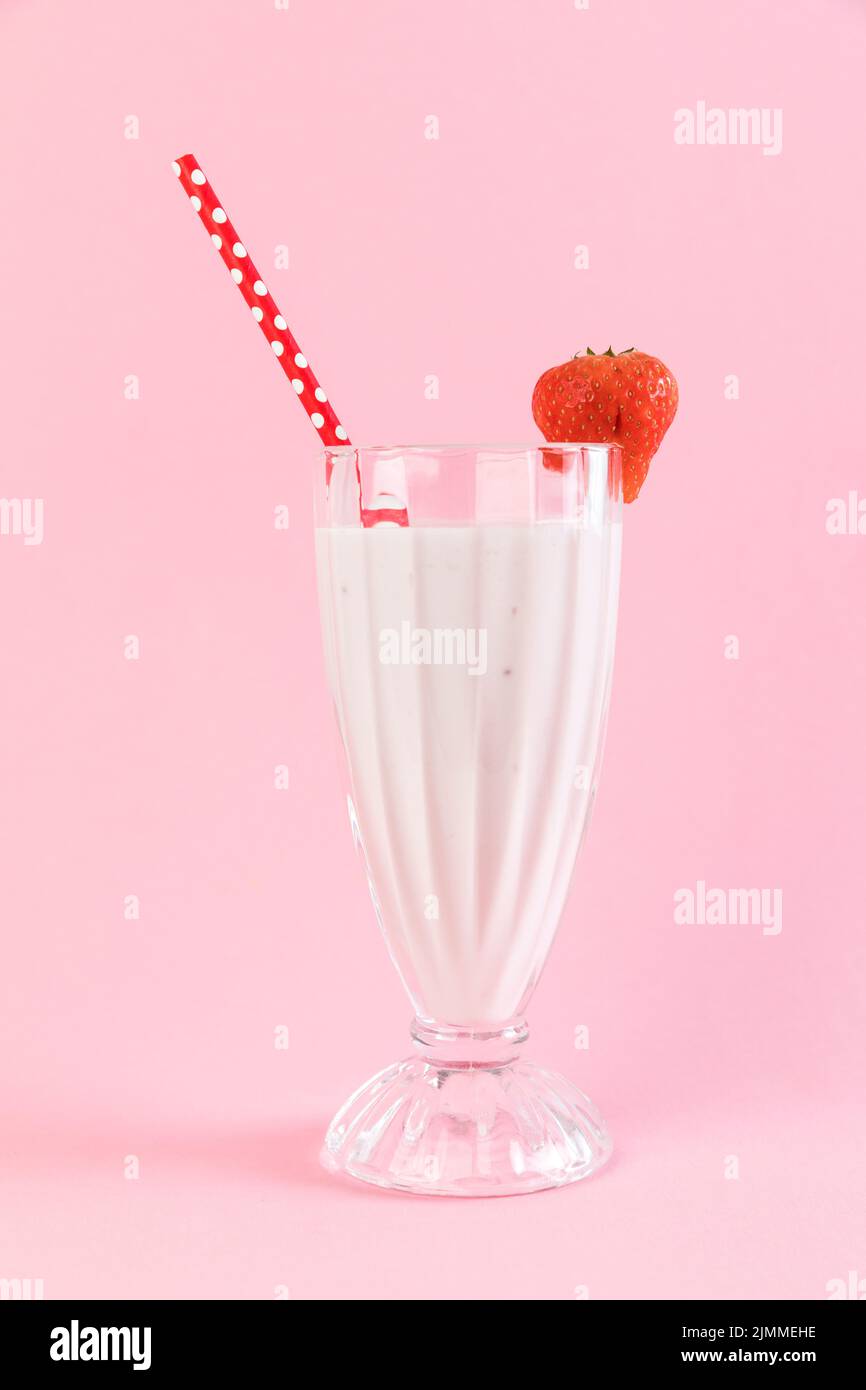 Gros plan en verre à Milk-Shake aux fraises avec fond rose Banque D'Images