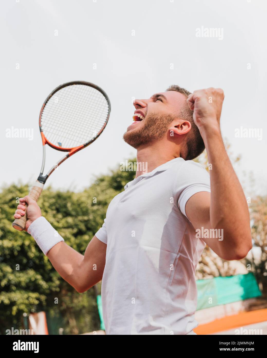 Jeune garçon sportif gagnant jeu de tennis Banque D'Images