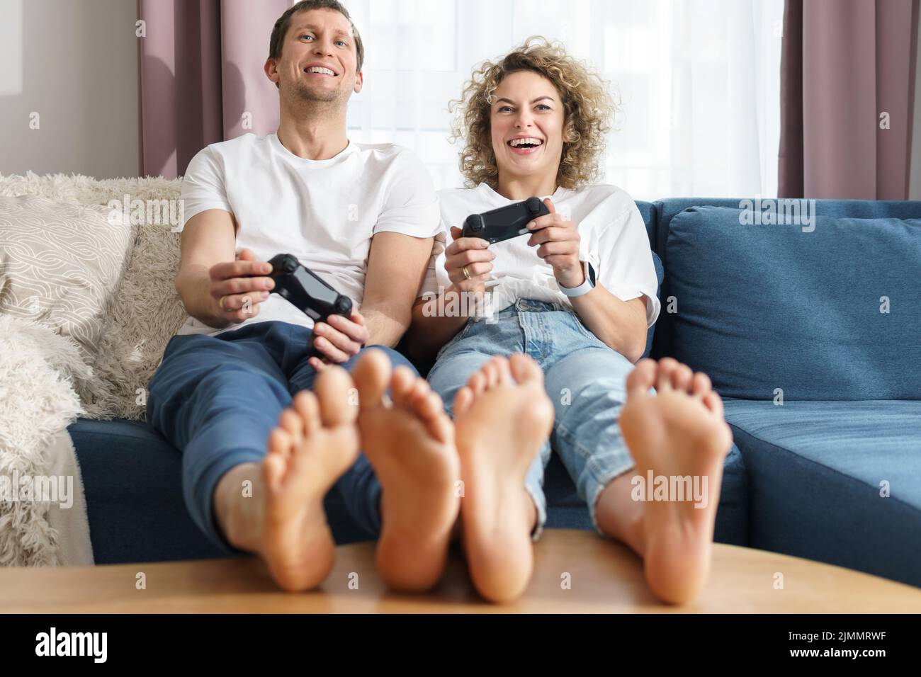 Couple avec un gamepads jouent à la console de jeux vidéo à la maison Banque D'Images