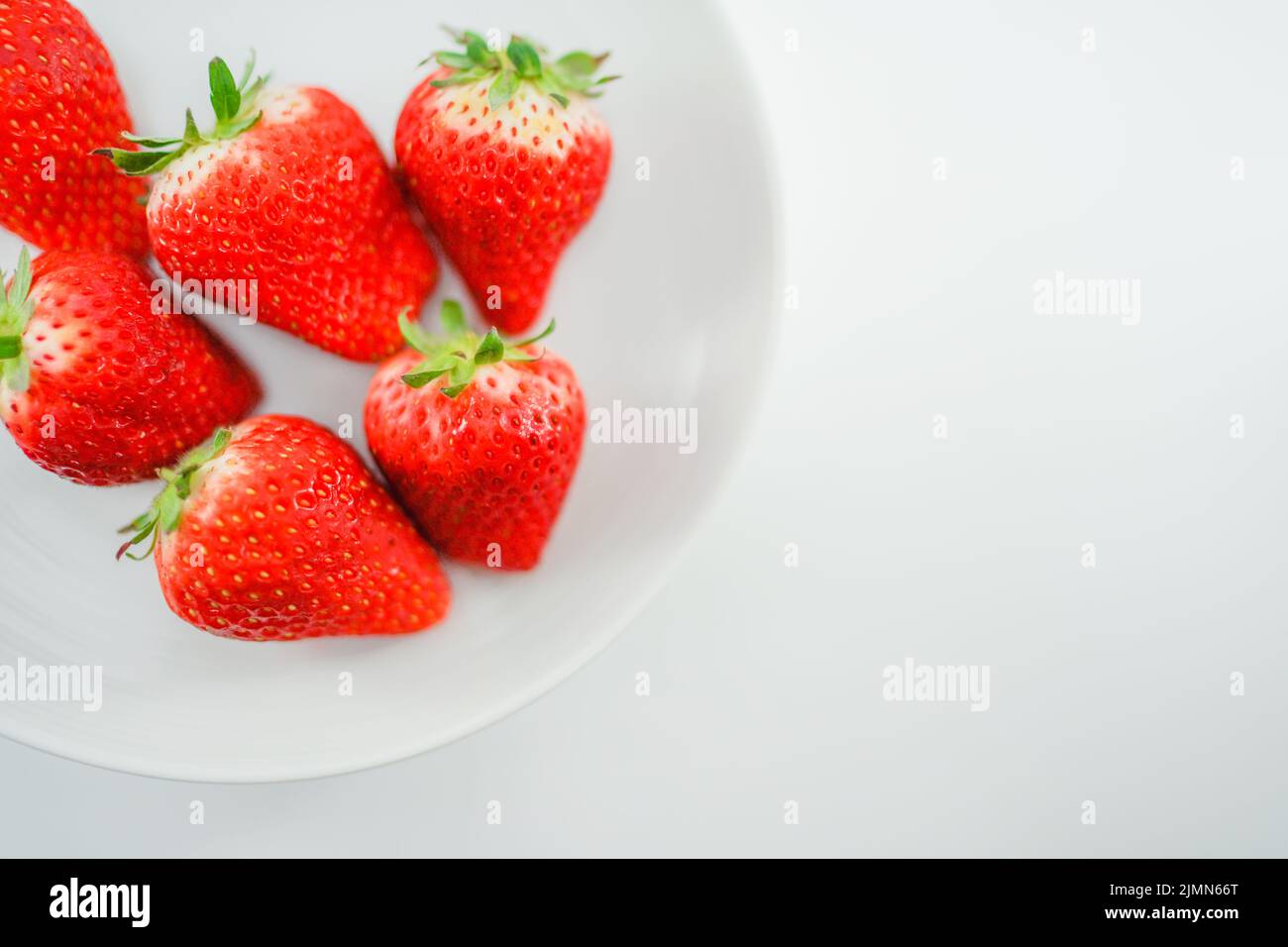 Des fraises fraîches et des plats blancs Banque D'Images