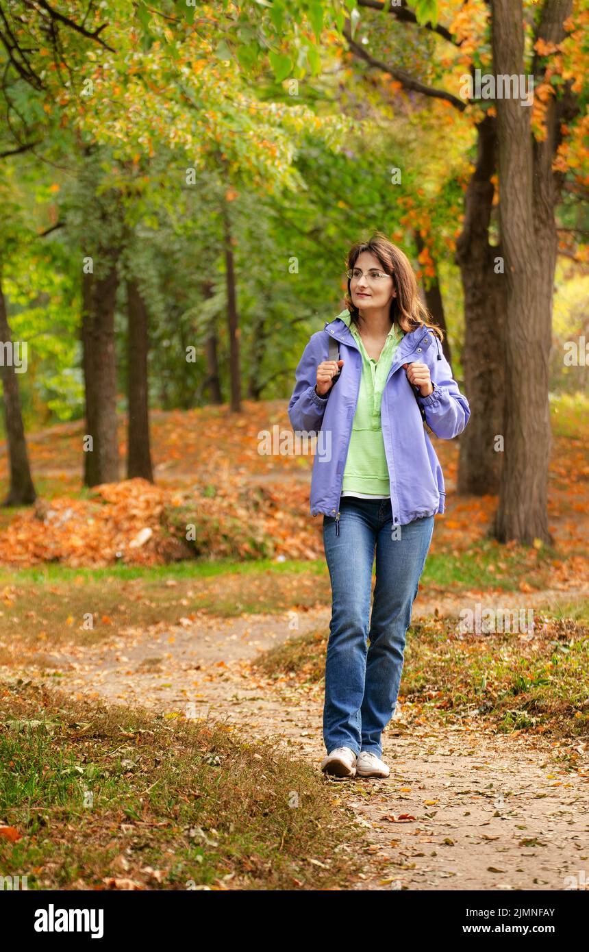 Modèle de femme caucasienne active d'âge moyen avec marche à dos dans les bois, heure d'automne Banque D'Images