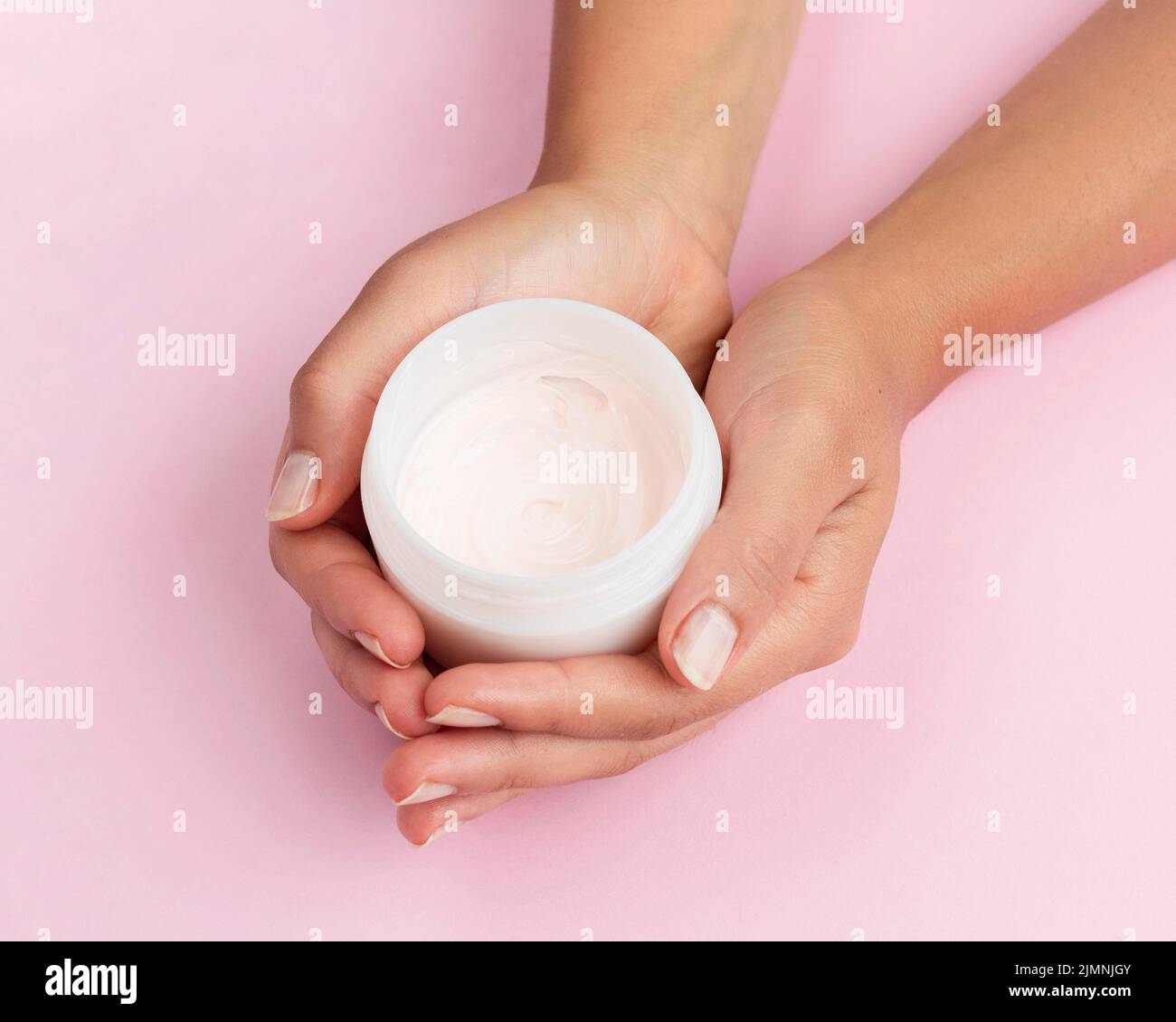 Femme tenant une boîte de crème pour le visage Banque D'Images