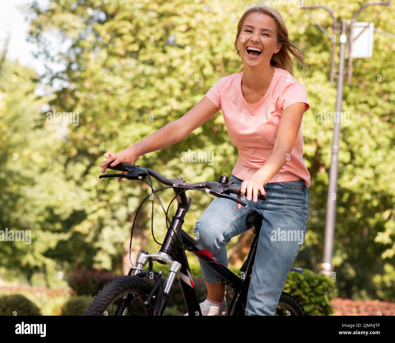 Femme à vélo riant Banque D'Images