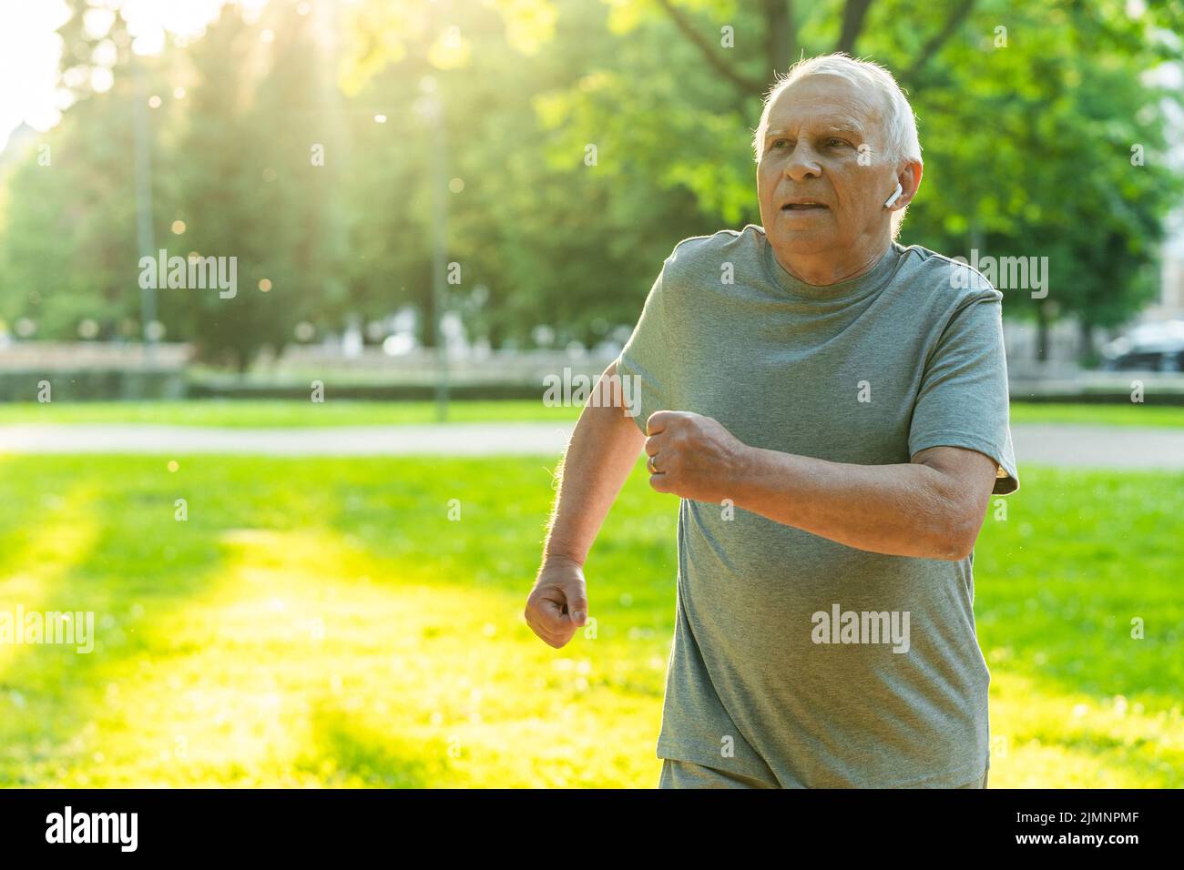 Homme âgé pendant son entraînement de jogging dans un parc de la ville Banque D'Images