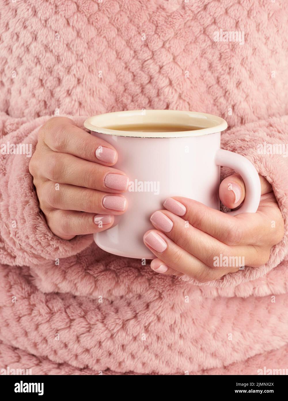 Matin café chaud le matin d'automne froid, mains tenant une tasse avec une boisson, atmosphère chaleureuse, vertical Banque D'Images