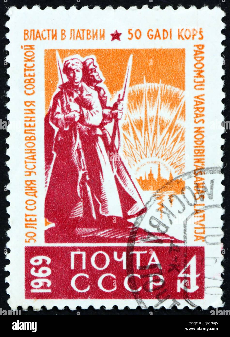 RUSSIE - VERS 1969: Un timbre imprimé en Russie montre des soldats sur la garde, des soldats de l'Armée rouge en premier plan, Riga en arrière-plan, 50 ans d'établissements Banque D'Images