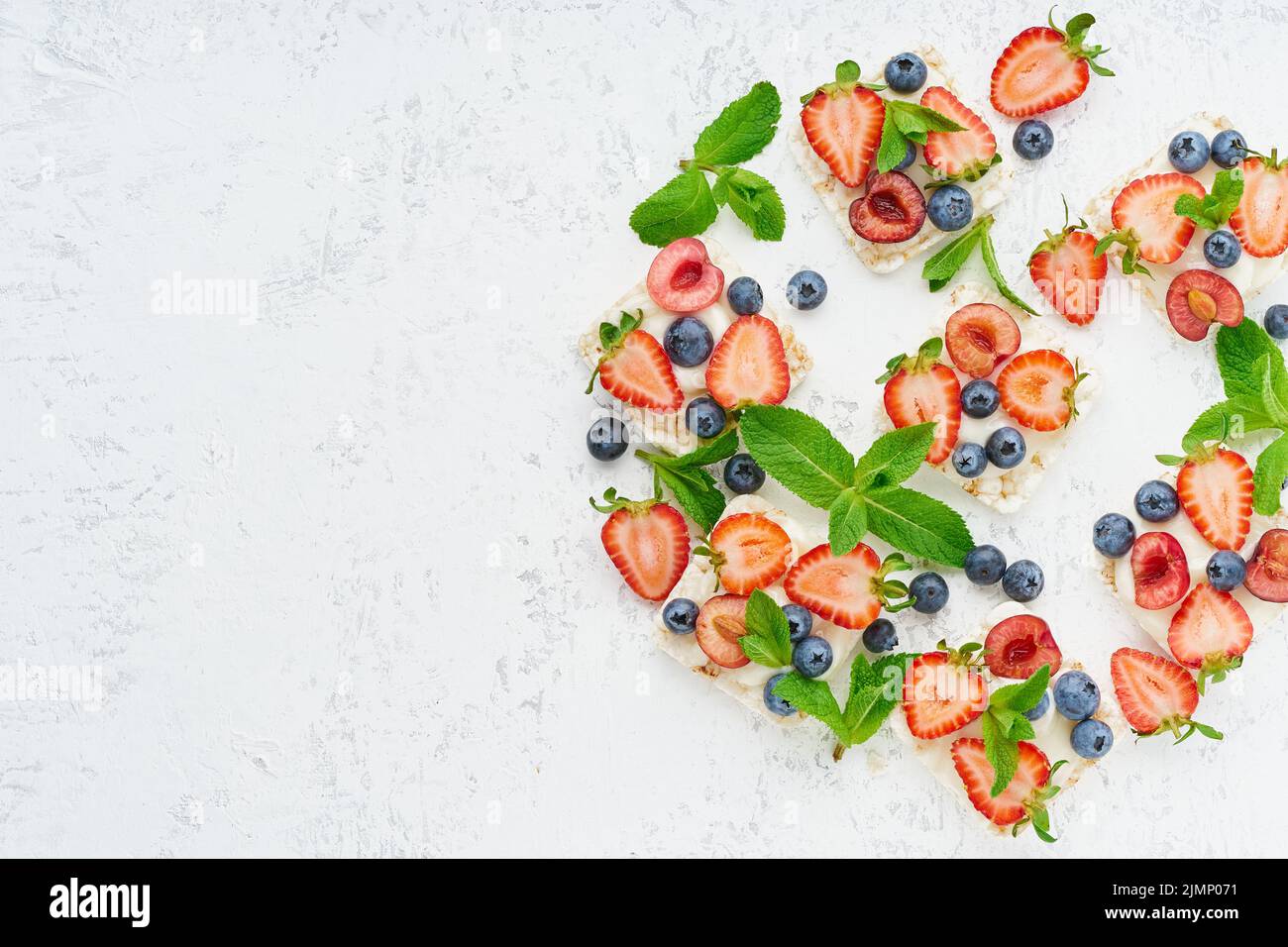 Faites monter des chips avec des baies et des fruits, un concept coloré sur fond pastel copie espace vue du dessus Banque D'Images