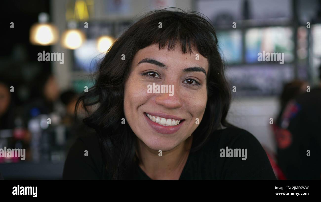 Portrait d'une fille latine hispanique souriant à l'appareil photo assis au café du restaurant Banque D'Images