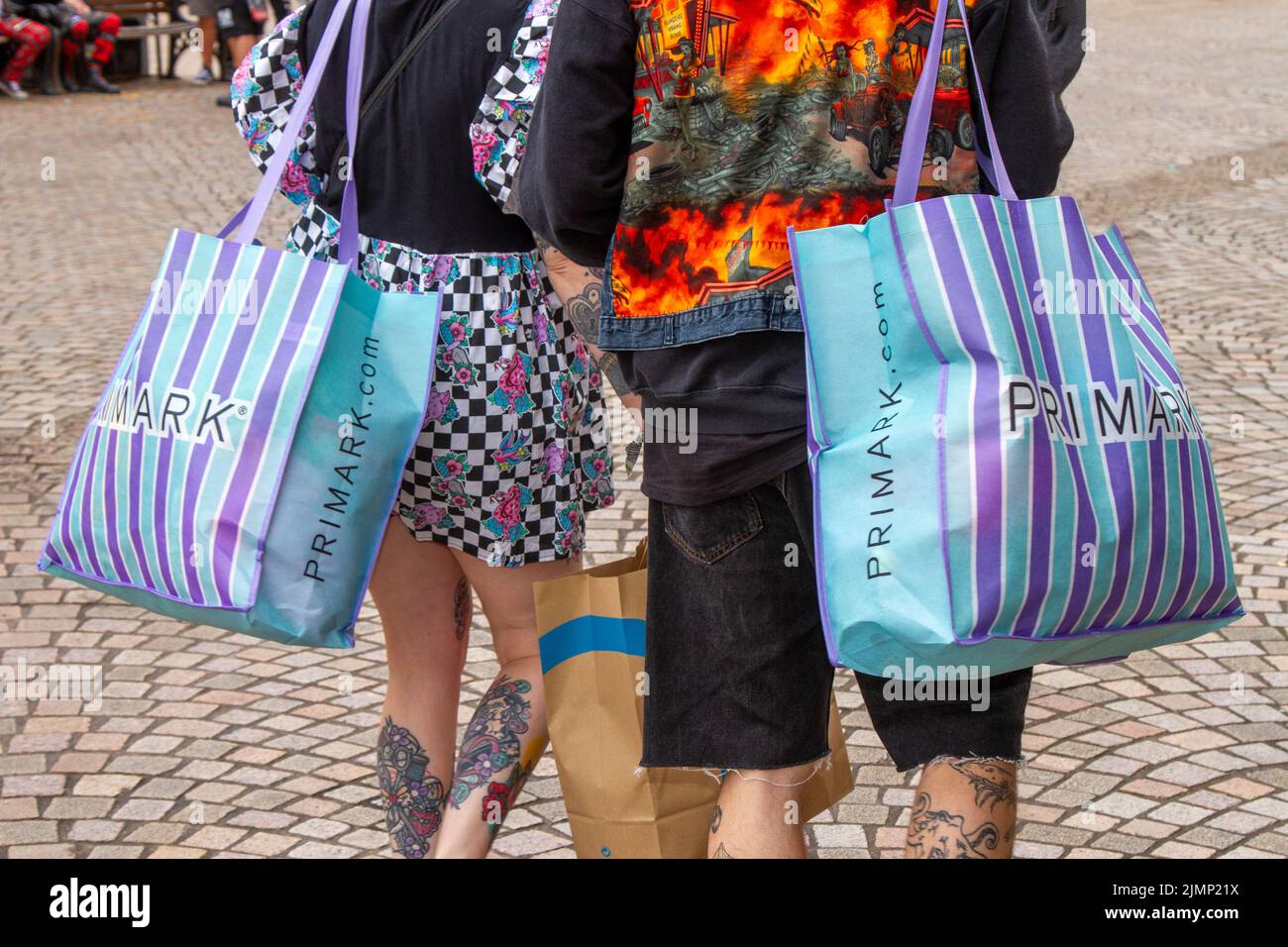 Le shopping des Punk Rockers tatoués, portant des sacs PRIMARK à rayures à Blackpool, Royaume-Uni Banque D'Images