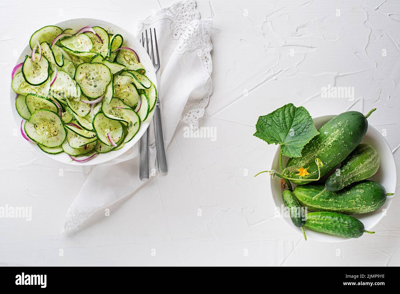 Salade de concombre frais avec vinaigrette sur fond de table blanc Banque D'Images