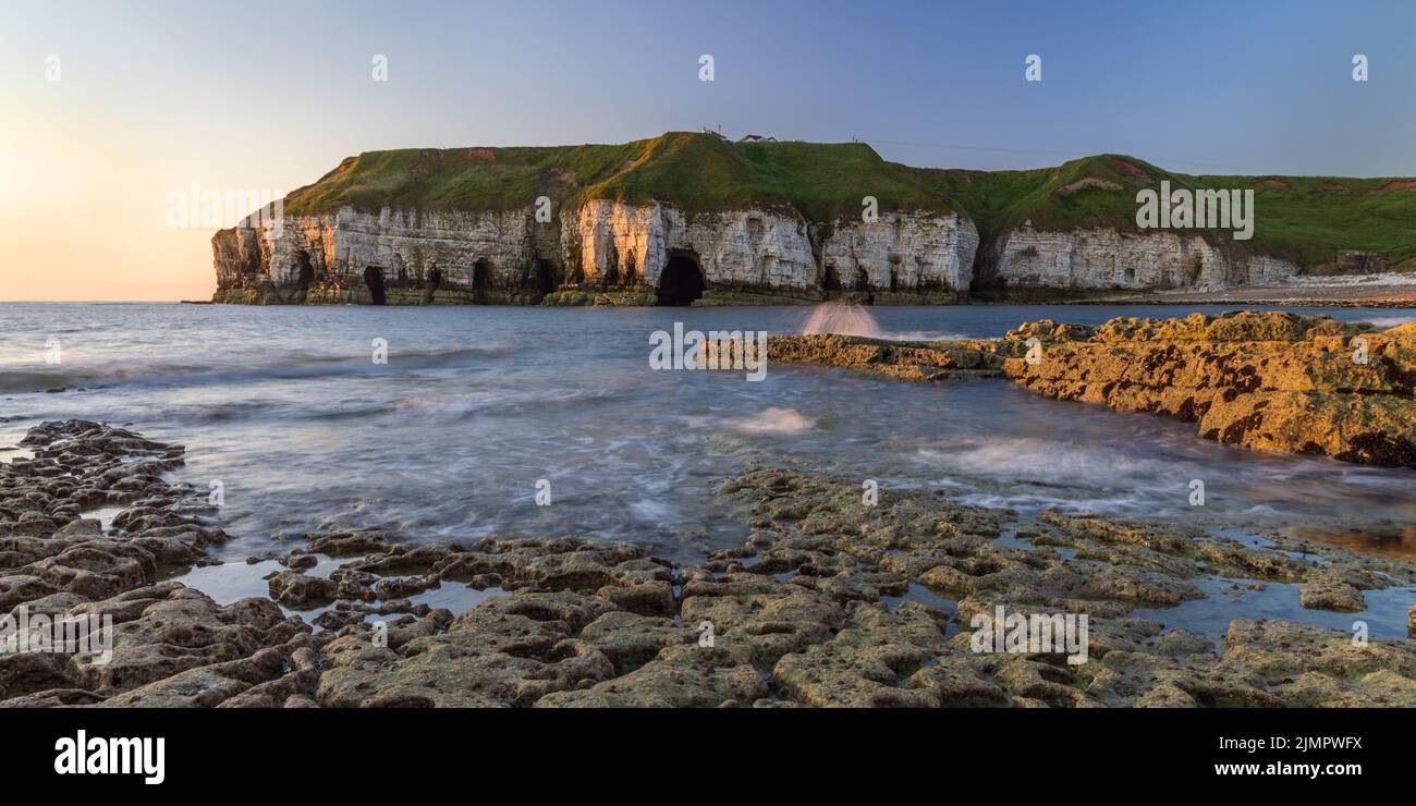 Falaises de craie et grottes marines à Thornwick Bay, sur la côte du Yorkshire de l'est, Angleterre, Royaume-Uni. Prise au lever du soleil. Banque D'Images