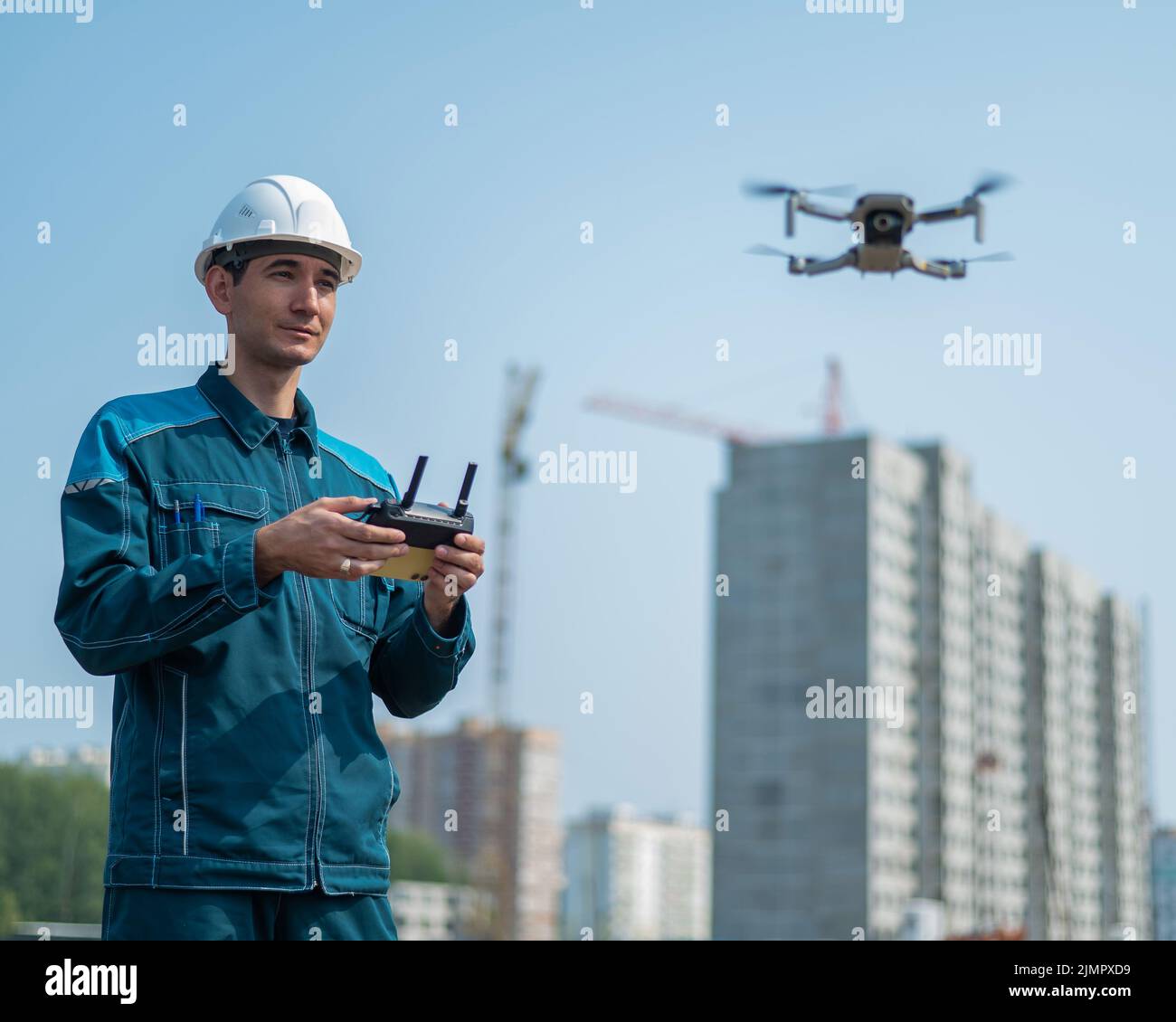 Un homme dans un casque et une combinaison contrôle un drone sur un  chantier de construction. Le constructeur effectue une supervision  technique Photo Stock - Alamy