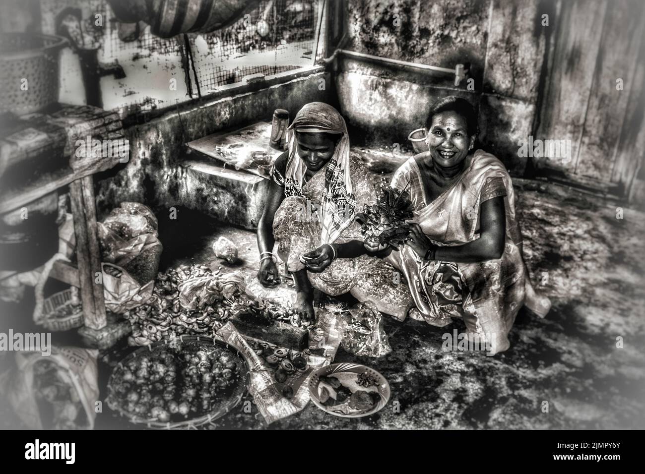 Deux femmes enlevant le revêtement de la noix de bételet pour préparer le fruit intérieur de la noix de bételet qui sera servi après la nourriture withh feuille de bétel, lime et pour certains tobacc. Banque D'Images