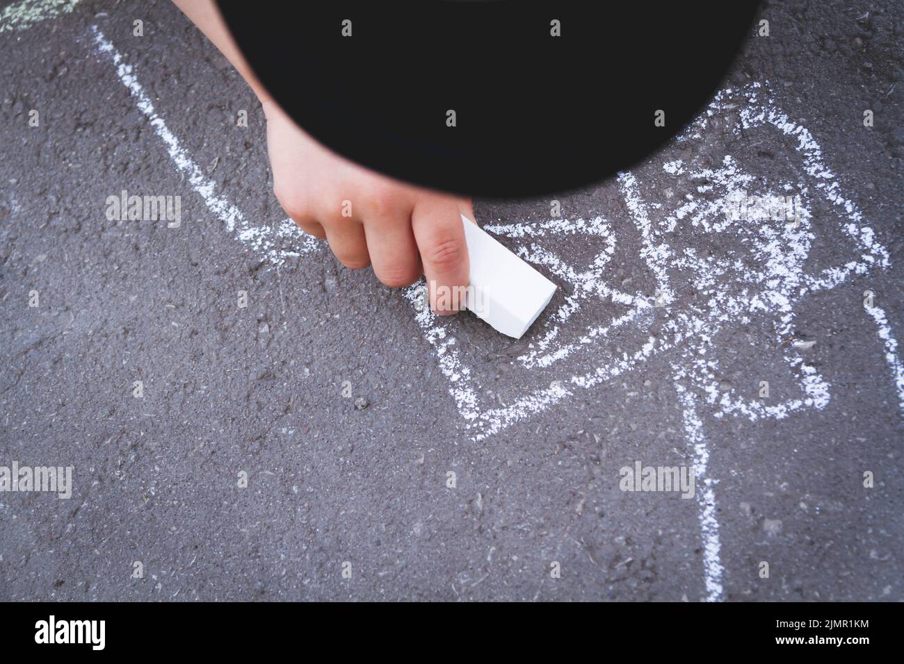 Les enfants s'attirent avec de la craie sur la route. Créativité des enfants dans la rue. Banque D'Images