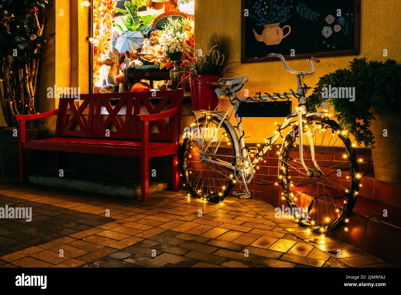 Un vélo décoré pour les vacances de Noël dans une rue nocturne. Banque D'Images