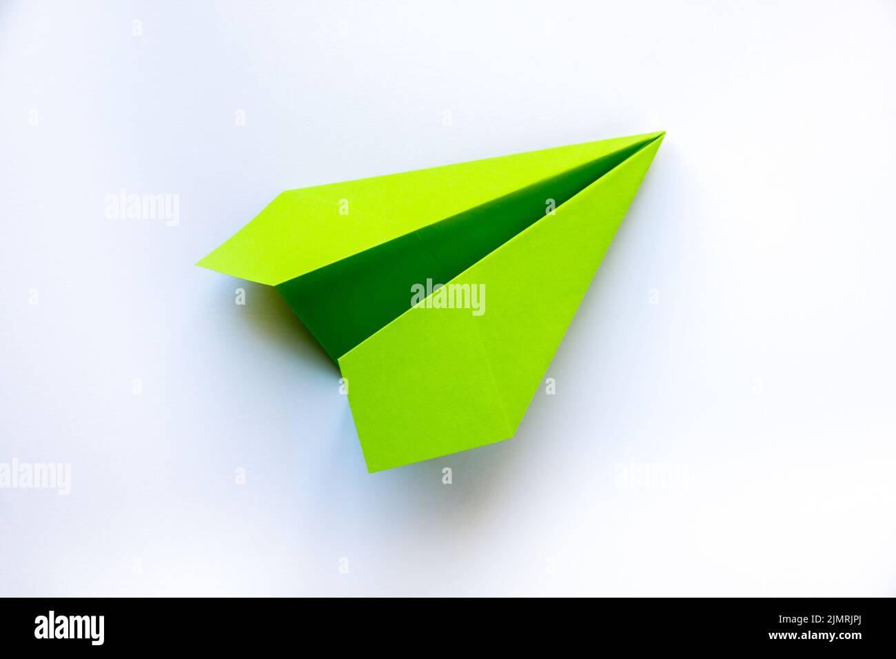 Avion de papier vert origami isolé sur fond blanc Banque D'Images