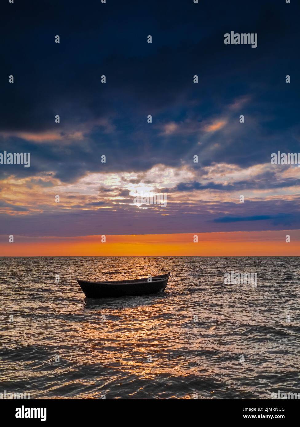 Bateau de pêche vide dans les rayons du soleil couchant. Banque D'Images