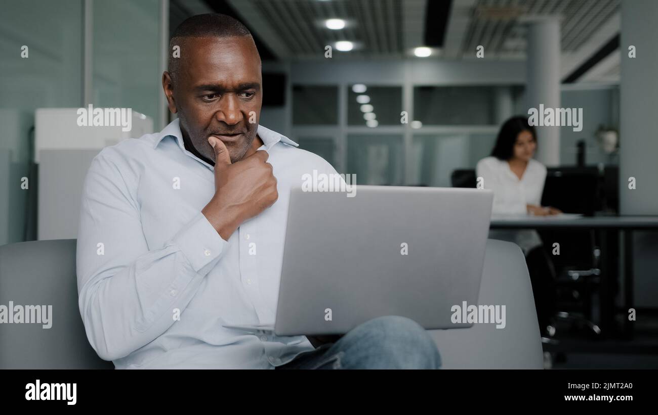 Un assistant homme d'affaires africain parle dans le chat vidéo de conférence consulte les clients professionnels à distance utilise la connexion WiFi d'entreprise sans fil Banque D'Images