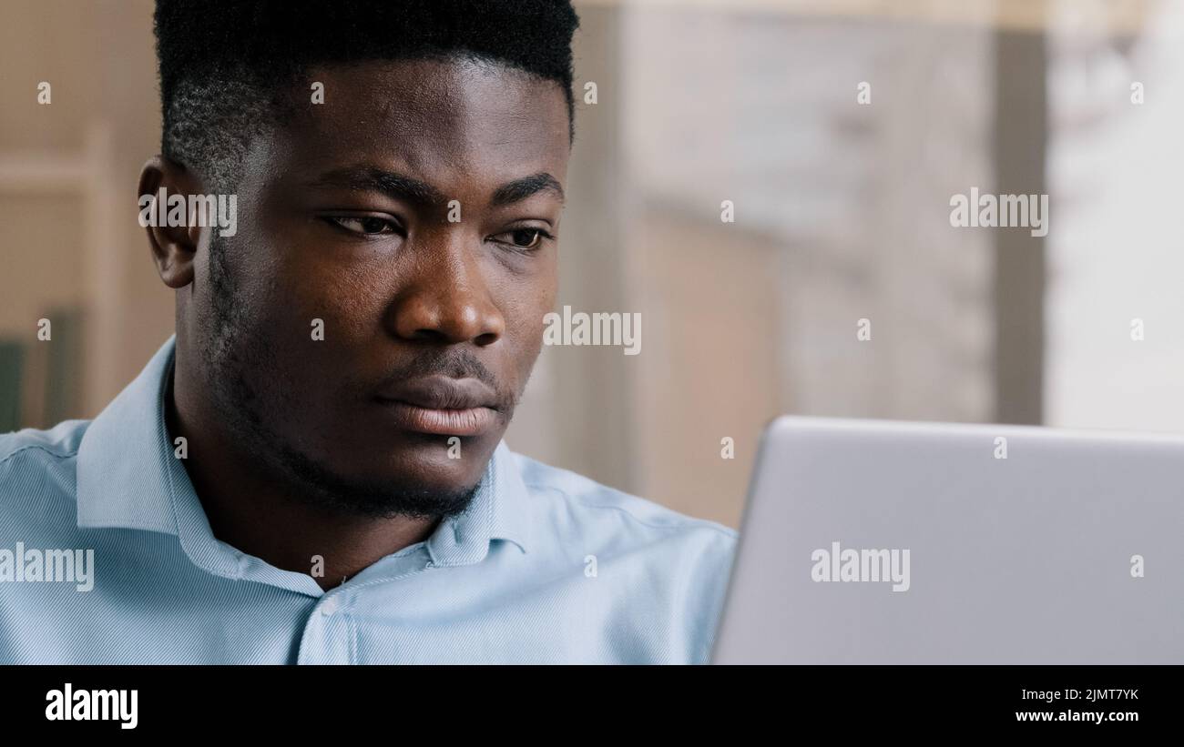 Gros plan africain américain jeune homme d'affaires indépendant web designer travailler en ligne sur ordinateur personnel utiliser wi-fi adulte boss Millenium man recherche Banque D'Images