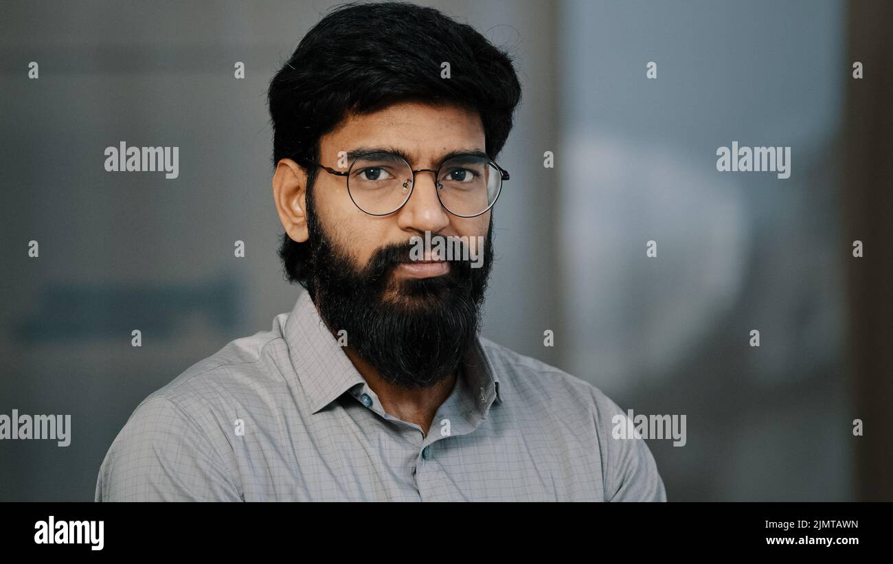 Arabe hispanique beau barbu homme confiant brunet gars en lunettes de vue tourner la tête à la caméra avec l'expression positive du visage indien jeune intelligent Banque D'Images