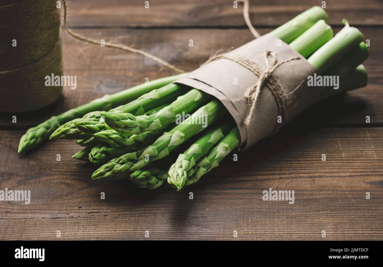 Bouquet d'asperges fraîches crues sur un bois brun, un produit sain Banque D'Images