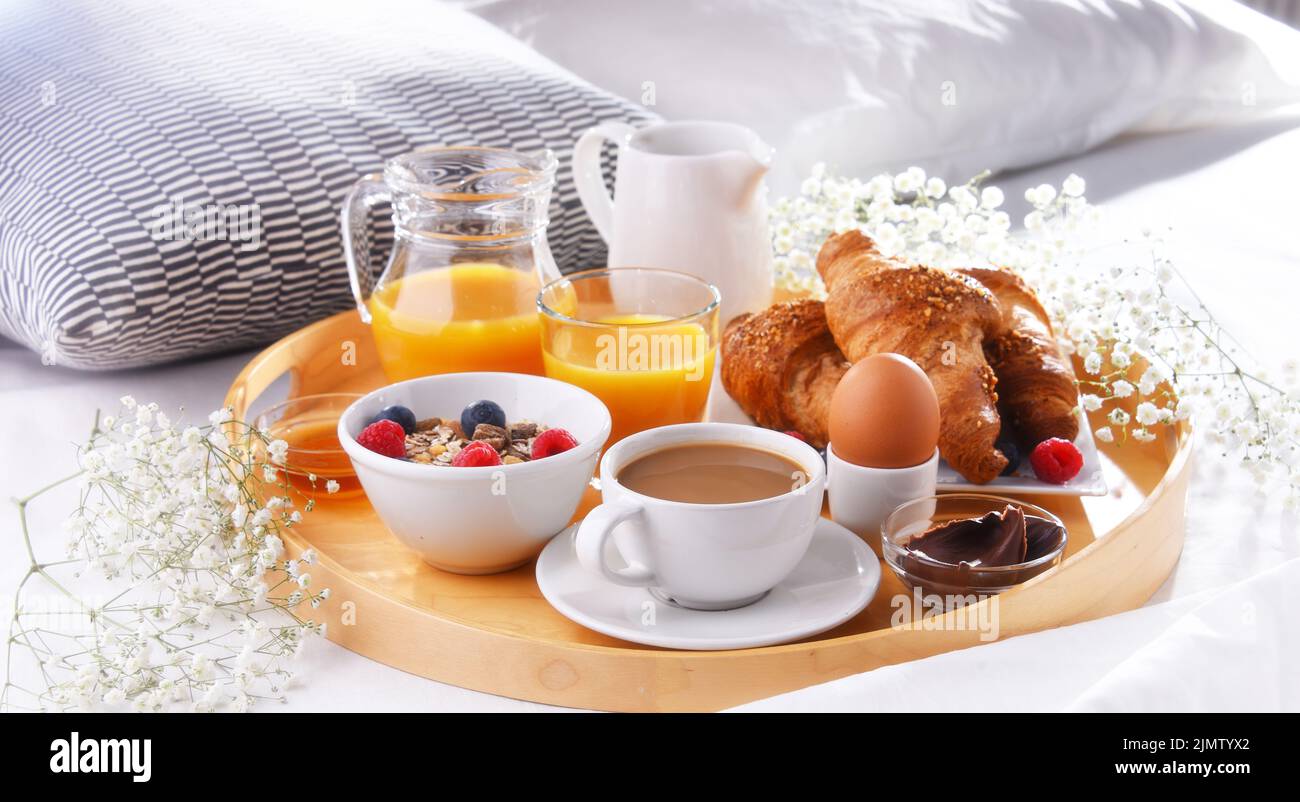 Un plateau avec petit déjeuner sur un lit dans une chambre d'hôtel. Banque D'Images