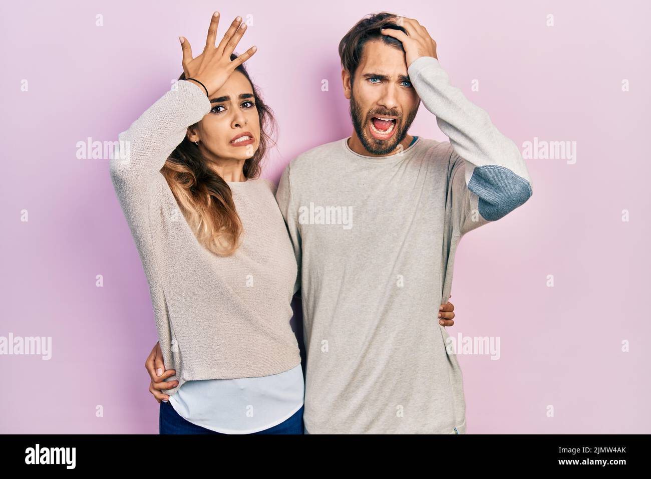 Jeune couple hispanique portant des vêtements décontractés surpris de la main sur la tête pour l'erreur, se souvenir de l'erreur. oublié, mauvais concept de mémoire. Banque D'Images Jeune couple hispanique portant des vêtements décontractés surpris de la main sur la tête pour l'erreur, se souvenir de l'erreur. oublié, mauvais concept de mémoire. Banque D'Images