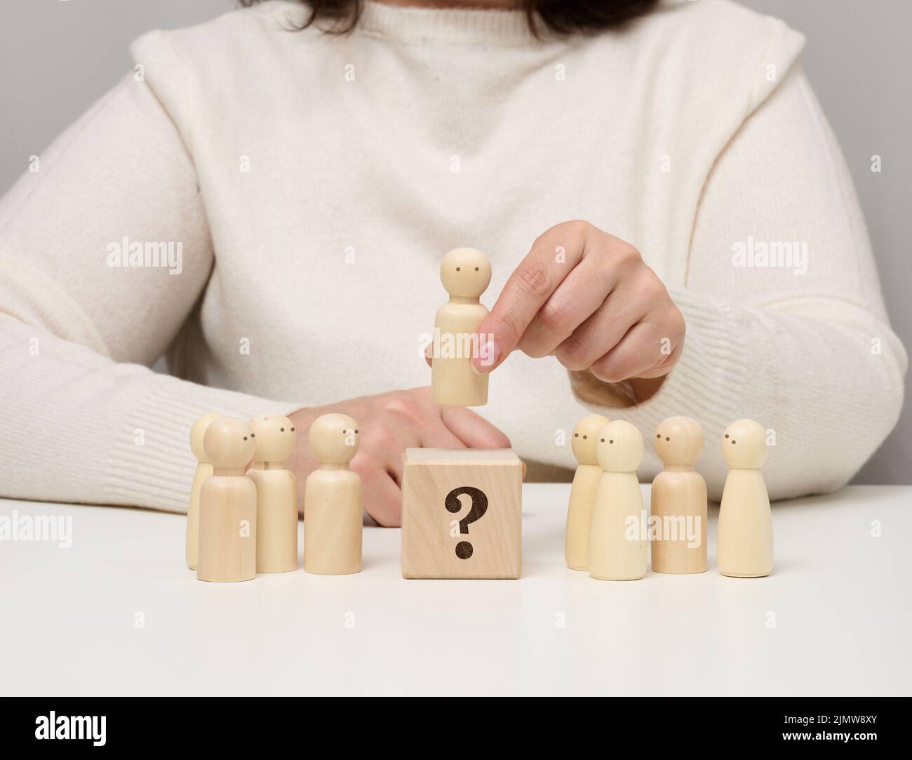 La femme garde la figurine en bois rouge séparée du groupe. Concept de développement de carrière, personne unique. Banque D'Images
