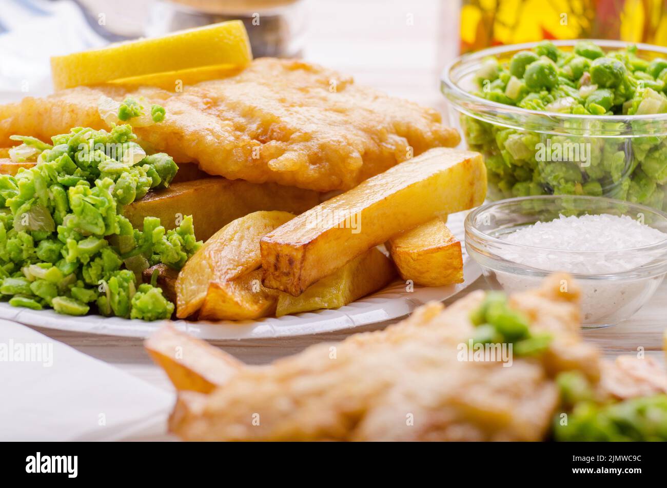 L'alimentation de rue britannique traditionnel fish and chips avec petits pois sur plaques de papier Banque D'Images