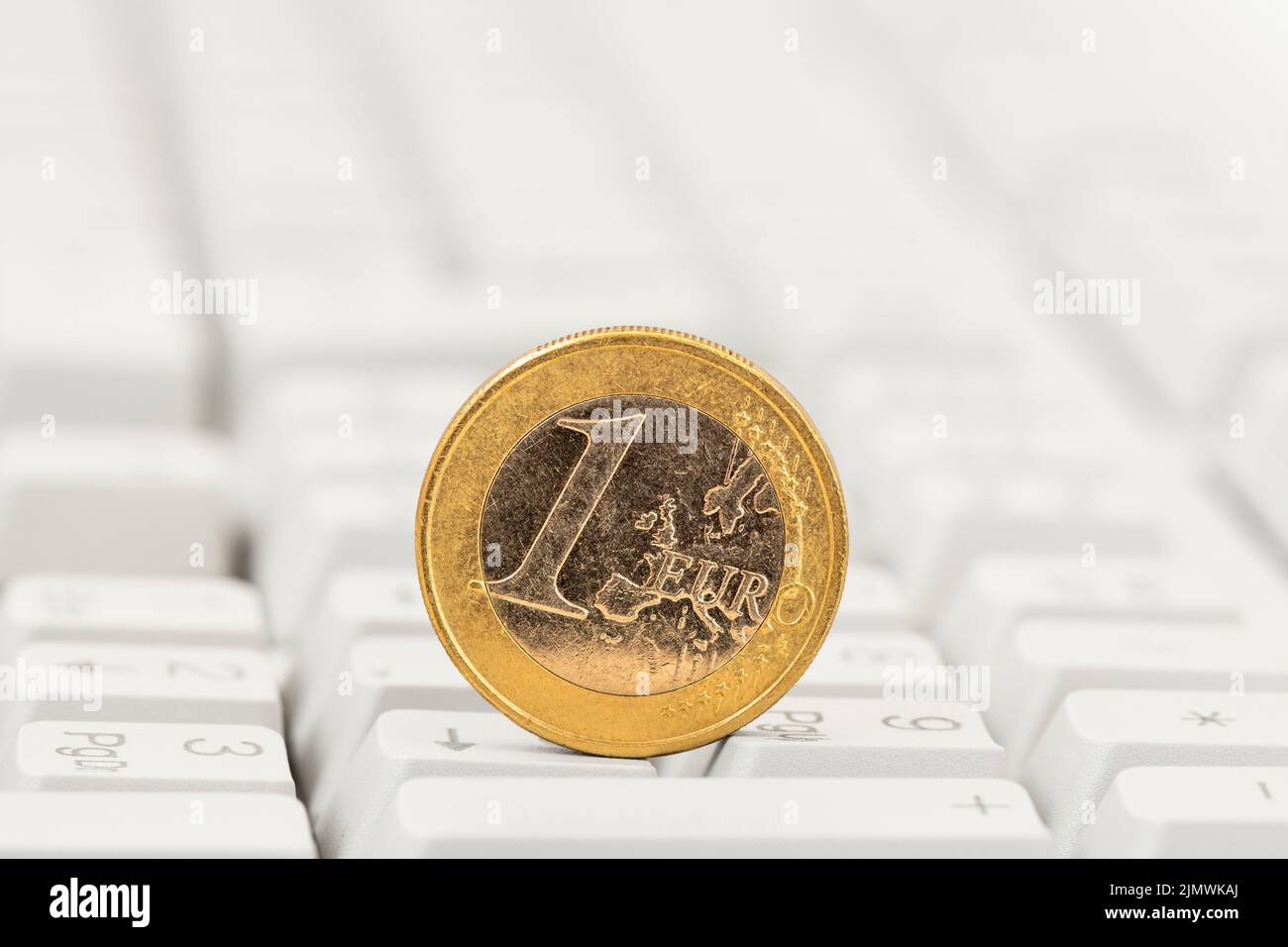 Une pièce d'un euro sur fond blanc du clavier d'ordinateur Banque D'Images