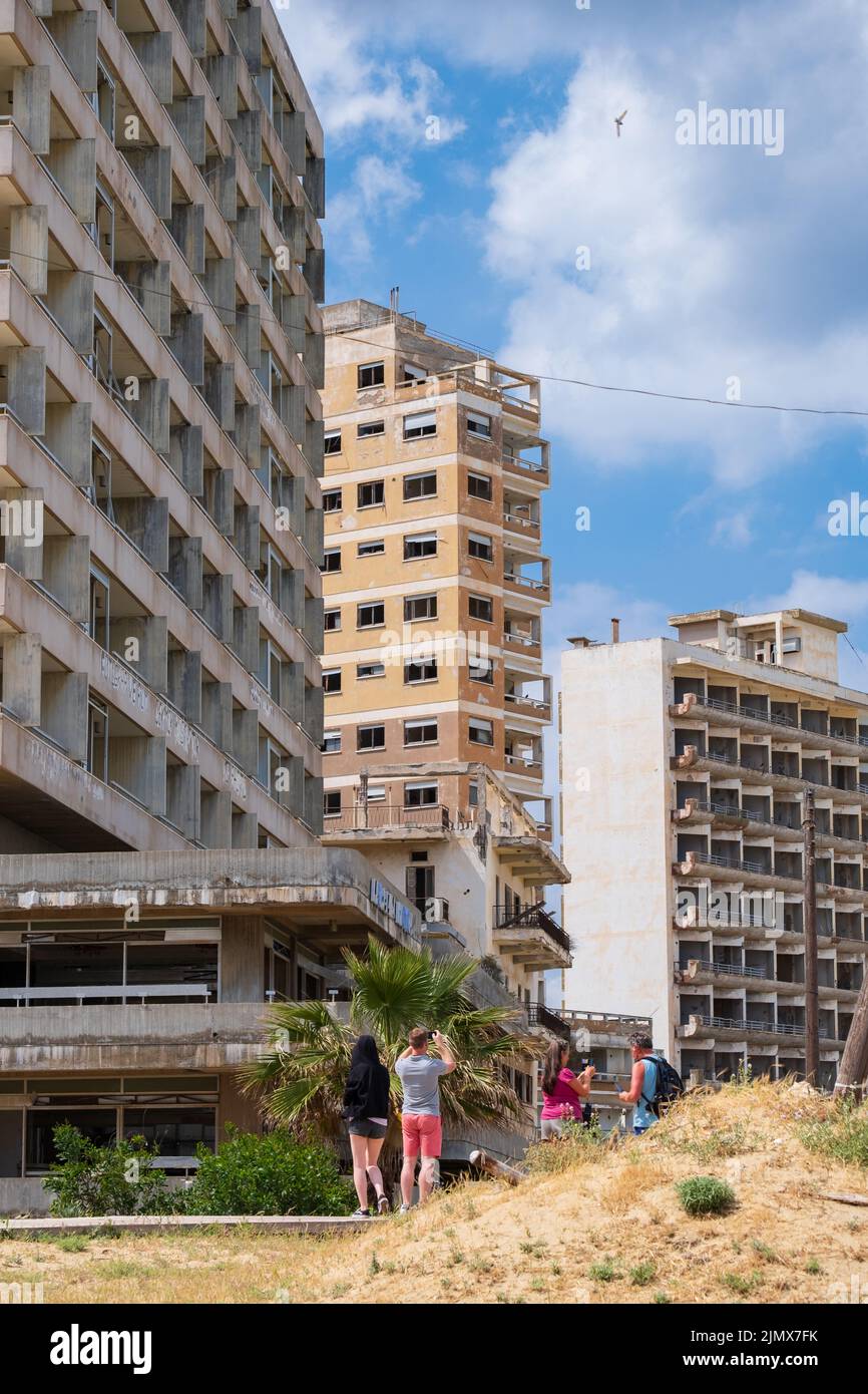 Les gens contemplent les hôtels abandonnés près de la plage de la ville fantôme de Varosha Famagousta par une journée ensoleillée. Banque D'Images