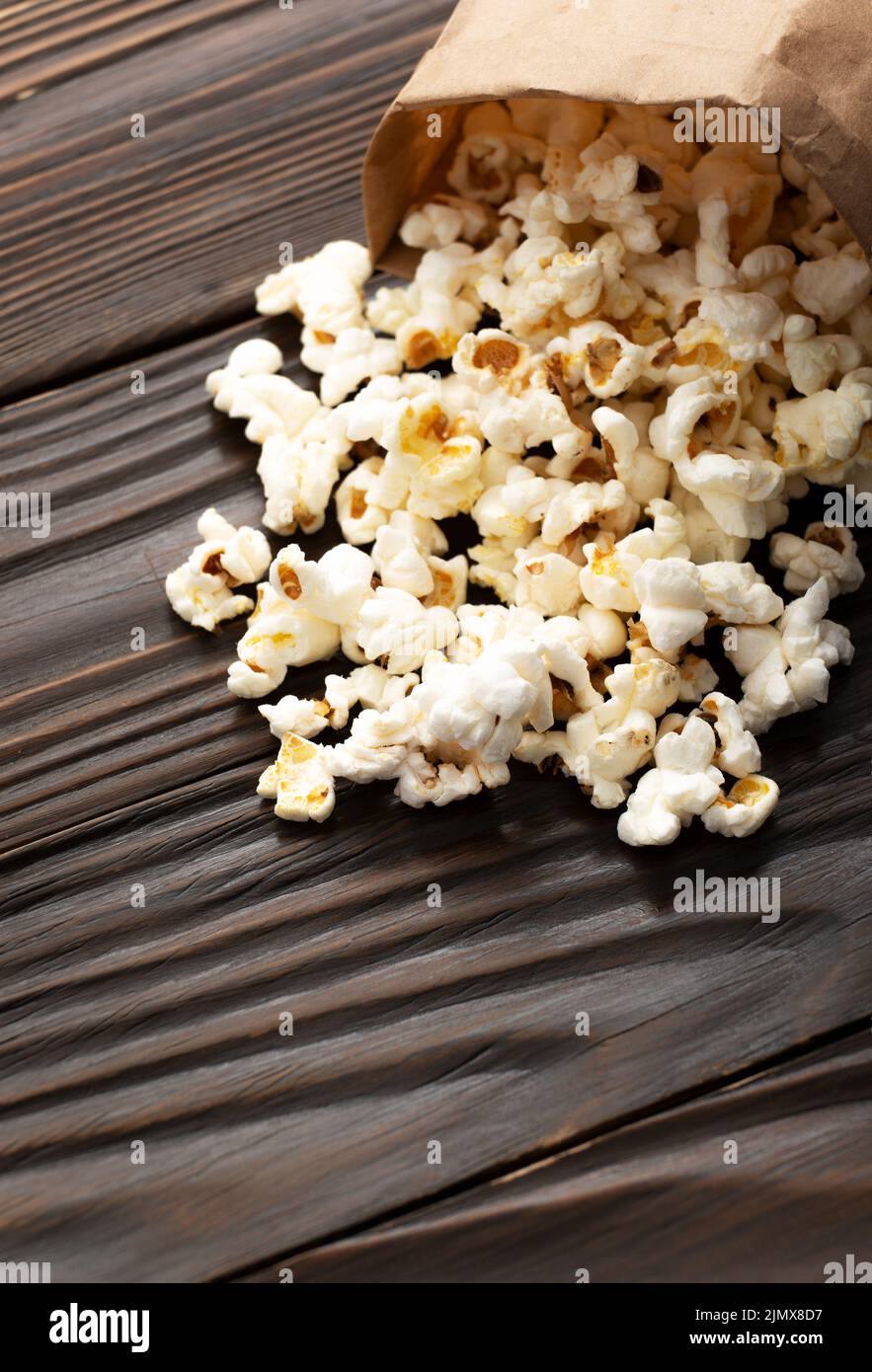 Collation de maïs poppée dans un sac en papier sur une clôture de table en bois Banque D'Images