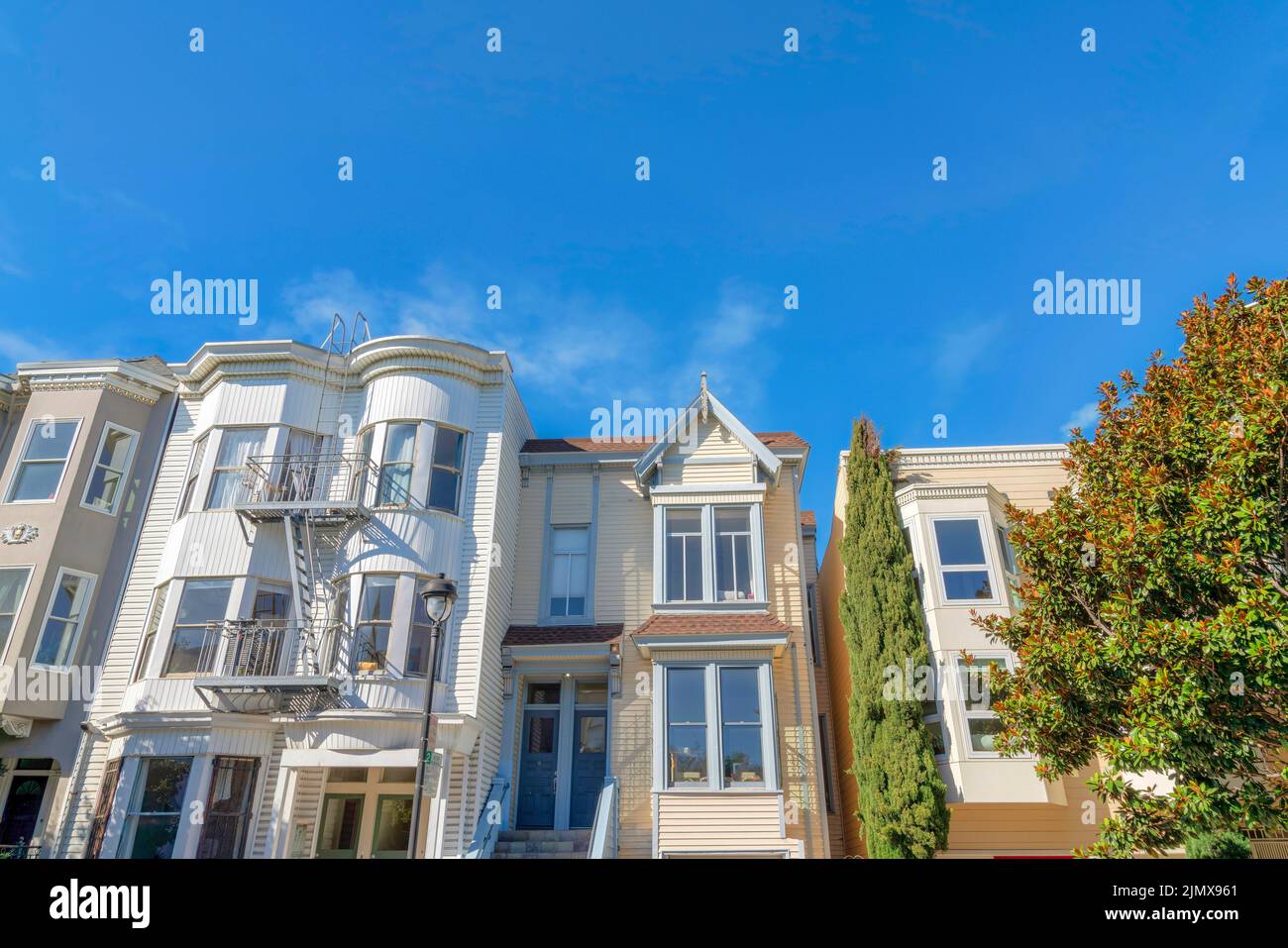 Façade des maisons en rangée à San Francisco, Californie. Il y a des maisons de ville sur la gauche avec un extérieur blanc et des escaliers d'urgence dehors à côté de la Te Banque D'Images