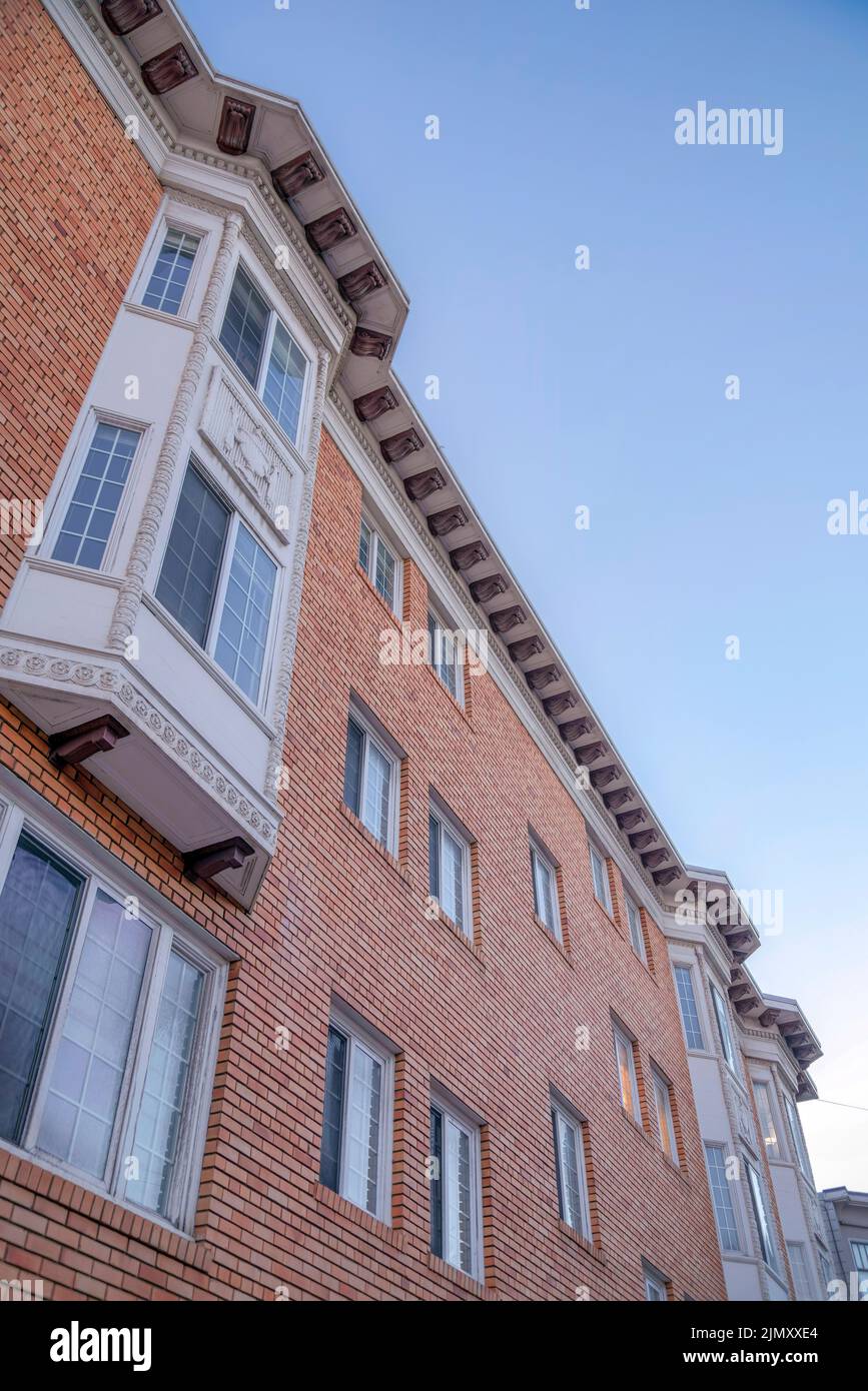 Immeuble résidentiel à San Francisco, Californie avec briques et corbel brun. Vue à angle bas d'une maison avec baie et fenêtres panoramiques contre Banque D'Images
