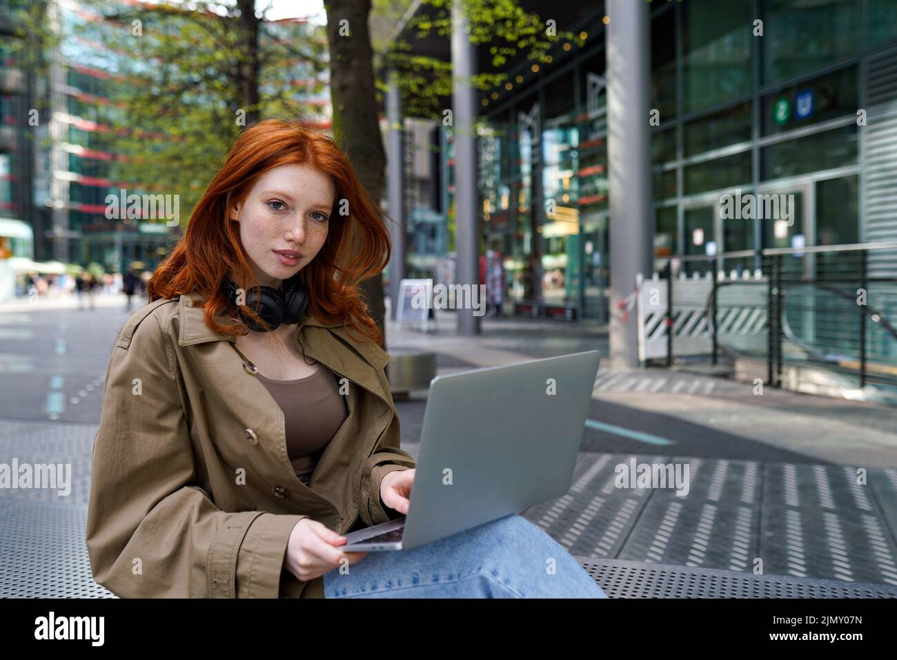 Ado redhead hipster fille utilisant un ordinateur portable sur la ville urbaine rue dehors. Banque D'Images