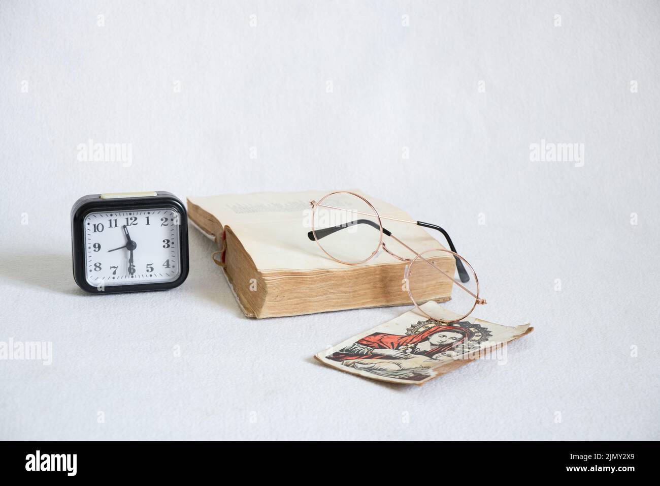 l'horloge et les lunettes de l'icône de la bible se trouvent sur un fond blanc, l'étude de la bible, la foi et la religion Banque D'Images