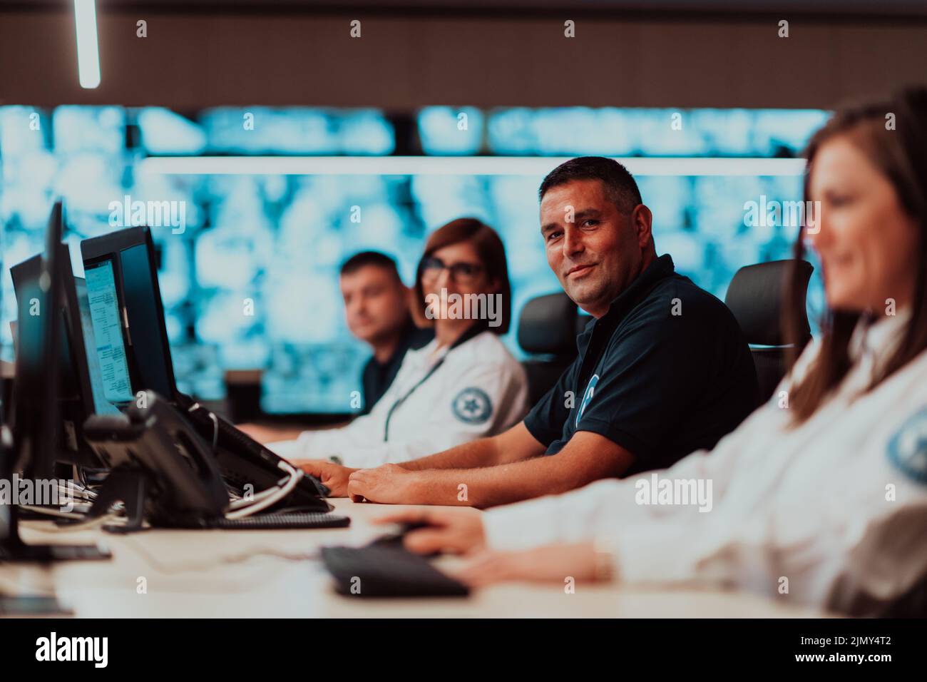 Groupe d'opérateurs de centre de données de sécurité travaillant dans une salle de vidéosurveillance regardant plusieurs moniteurs officiers surveillant plusieurs moniteurs Banque D'Images