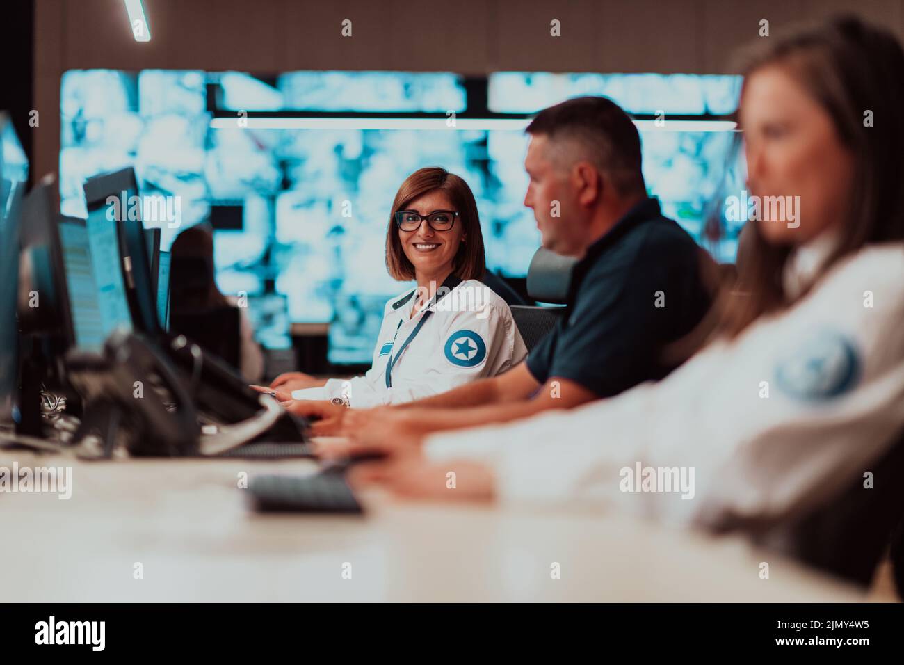 Groupe d'opérateurs de centre de données de sécurité travaillant dans une salle de vidéosurveillance regardant plusieurs moniteurs officiers surveillant plusieurs moniteurs Banque D'Images