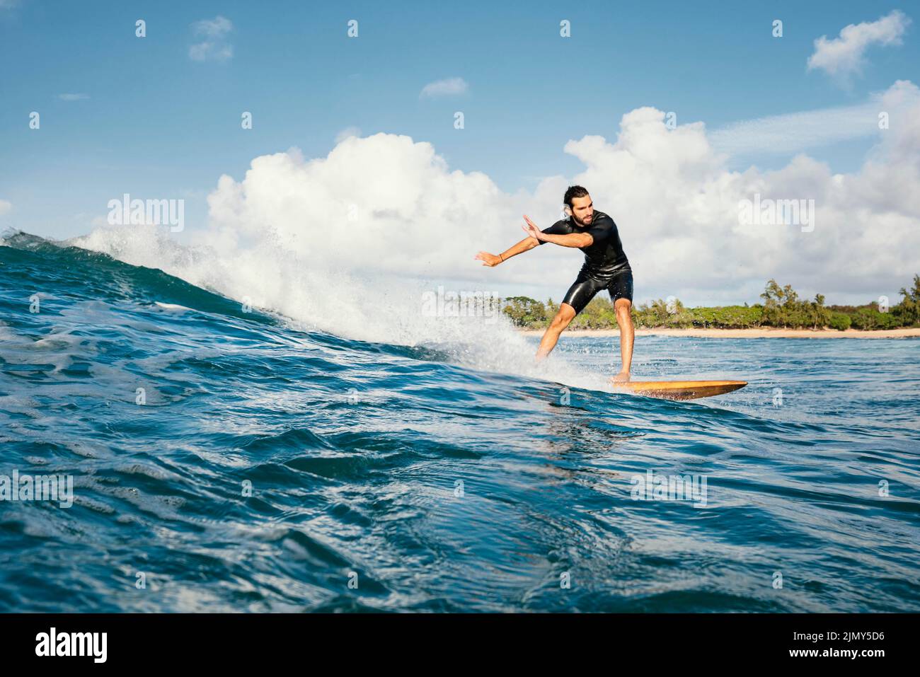 Homme à cheval sur sa planche de surf ayant le bon temps long coup Banque D'Images