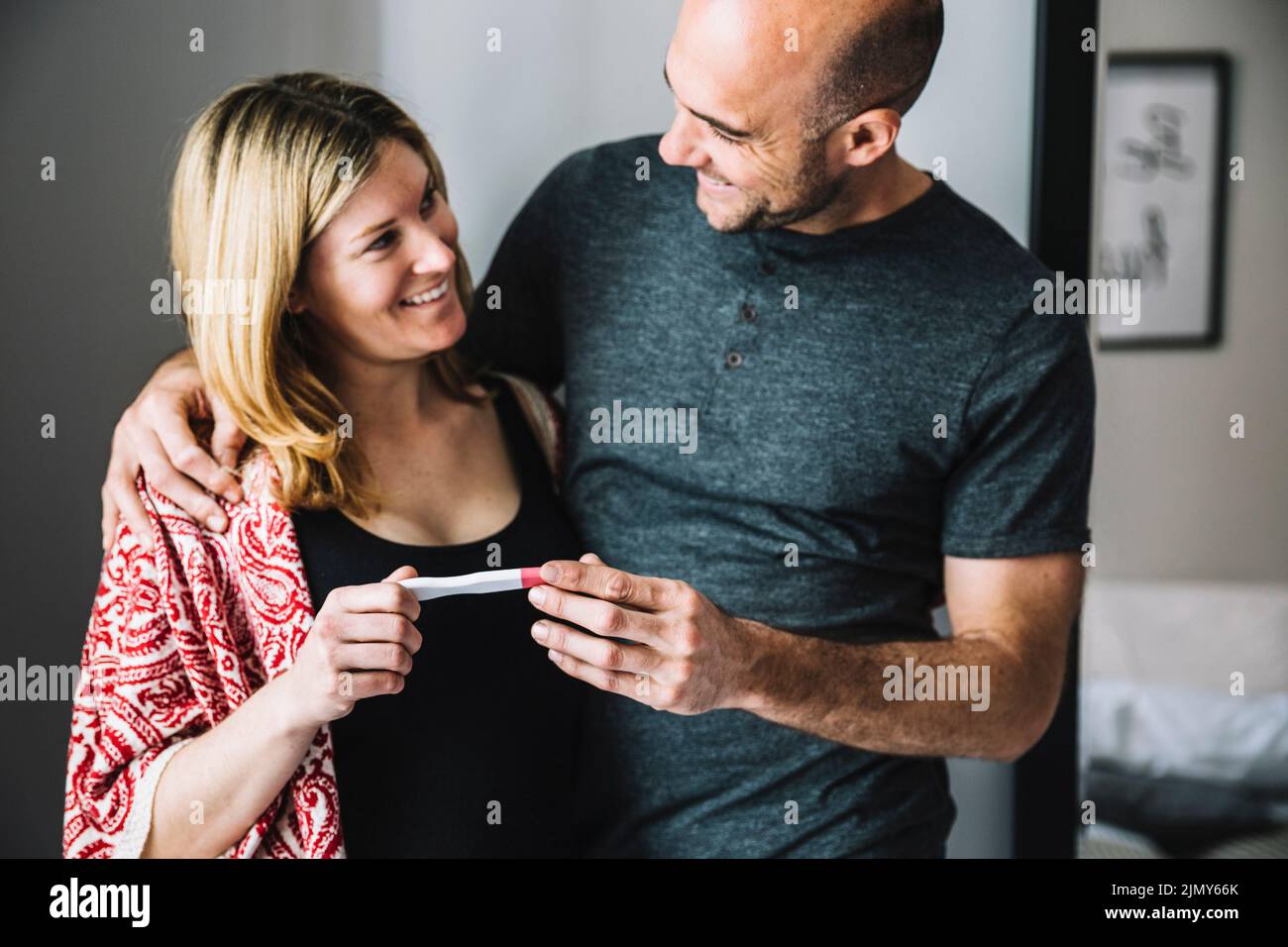 Femme heureuse mari regardant le test de grossesse Banque D'Images